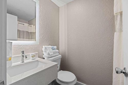 奥兰多Super 8 by Wyndham Kissimmee-Orlando的白色的浴室设有水槽和卫生间。