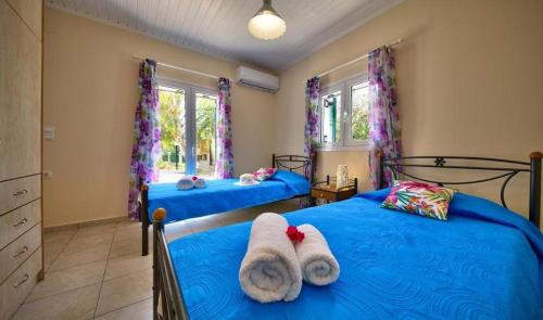 雷夫卡达镇Villa Esperanza by Imagine Lefkada的卧室内的两张床,配有毛巾