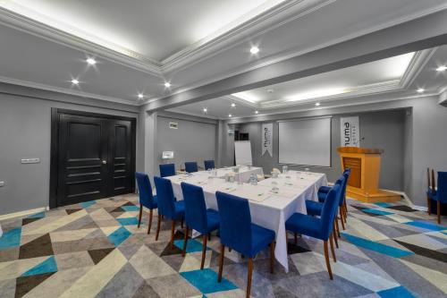 阿拉尼亚Numa Port Hotel的一间会议室,配有白色的桌子和蓝色的椅子