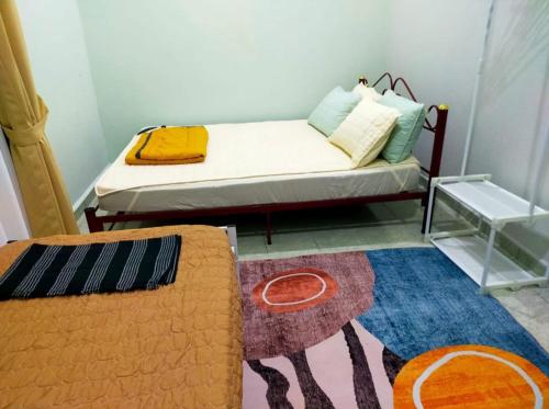 Pasir MasWK HOMESTAY PASIR MAS的小房间,配有床和地毯