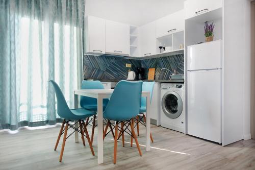伊里斯斯Okean Apartments的厨房配有桌椅和洗衣机。