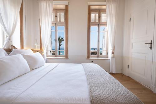 切什梅Nars Ilica Hotel Beach Adults Only 12Plus的卧室设有一张带窗户的白色大床