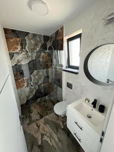 锡比乌Casa Lucia的一间带水槽、卫生间和镜子的浴室