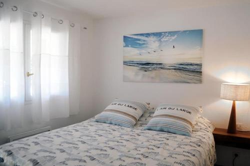 勒·雷约尔·卡纳德尔·苏尔Superbe, rénové, au calme, plage 200m, terrasse vue Mer!的一间卧室配有一张带两个枕头的床