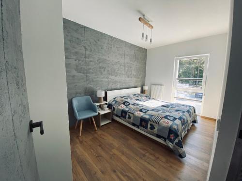 博格泽利卡Apartament Amilado的卧室配有床、椅子和窗户。