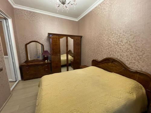 甘贾Veyasum Guest House的一间卧室配有一张床、梳妆台和镜子