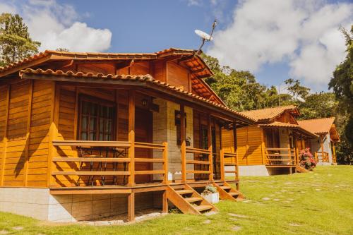 多明戈斯马丁斯Pousada Gagno的木屋设有门廊和草地庭院