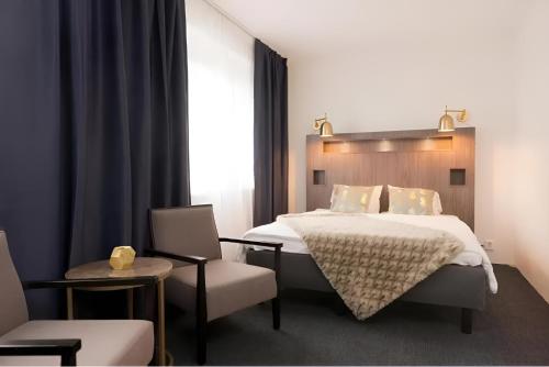 斯德哥尔摩Communia Hotel Residence的一间卧室配有一张大床和一把椅子