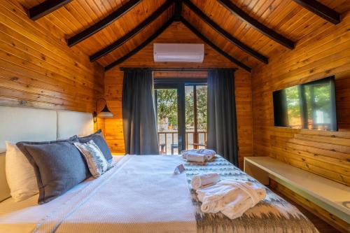 博德鲁姆Dolce Vita Luxury Bungalows的卧室配有木墙和窗户。
