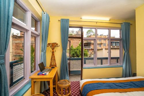 加德满都Kwabahal Boutique Hostel的一间卧室配有一张床,阳台配有窗户