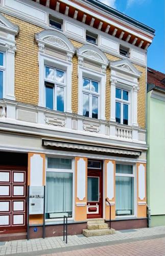 施韦特Ferienwohnung Karpe的街道上设有红色门窗的建筑