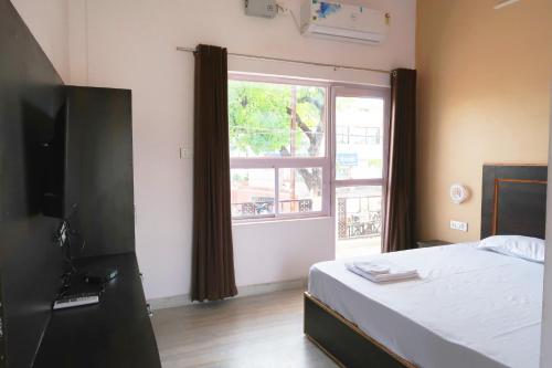 克久拉霍Aarambh Residency的一间卧室设有一张床和一个大窗户