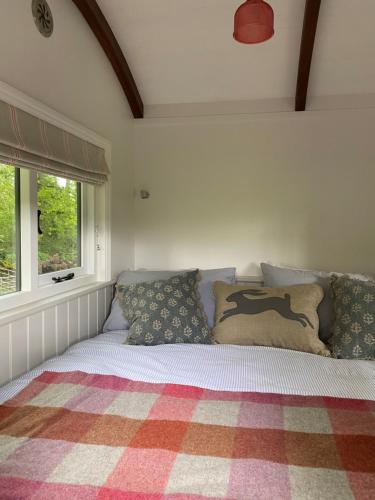佩特沃斯Coachroad Shepherds Huts的卧室内的一张带枕头的床