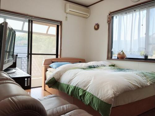 相模原市friendly 民宿的一间卧室设有两张床、一台电视和一扇窗户。