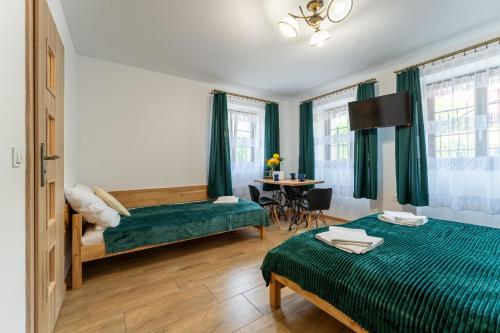 耶莱尼亚古拉Dom Krawca - pod Chojnikiem的酒店客房设有两张床和一张桌子。