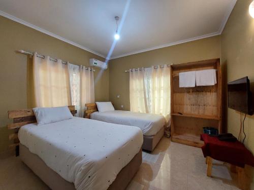莫希Maili 6 Private Apartments的一间卧室配有两张床和电视。