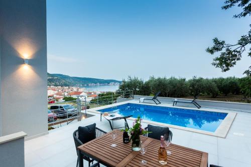 科米扎Seaside Elegance Suites的一个带桌子和游泳池的庭院