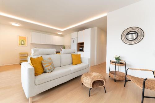 阿格特Apartamento Roca Paraíso De Agaete Con Vistas Panorámicas的客厅配有白色沙发和黄色枕头。