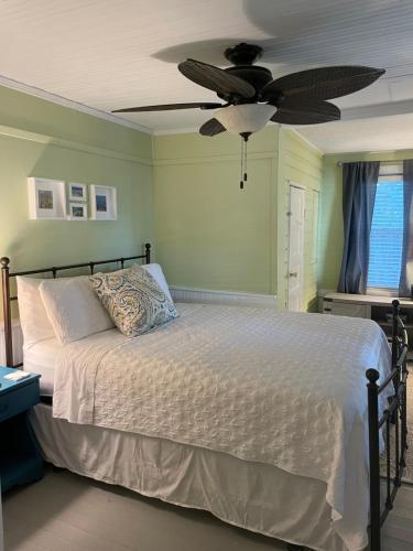 圣奥古斯丁3BR/3BA Charming Key West Style Home in Downtown Saint Augustine的一间卧室配有一张带吊扇的床