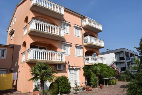 茨里克韦尼察拉万达公寓的粉红色的建筑,设有白色阳台