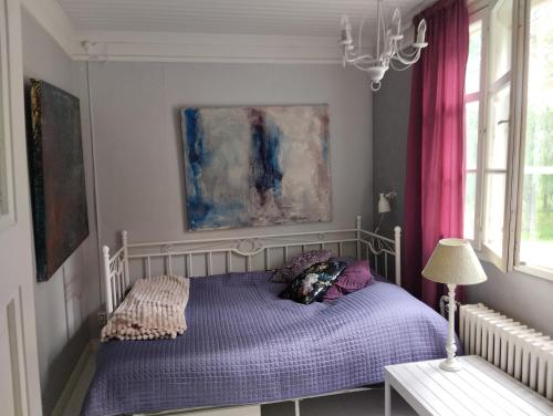 拉赫蒂Villa Anna的一间卧室配有一张带紫色床单和粉红色窗帘的床