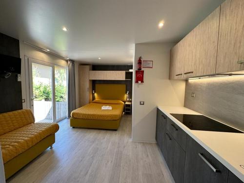 毕博纳的码头石榴露营地的一间带一张床的房间和一个带沙发的厨房
