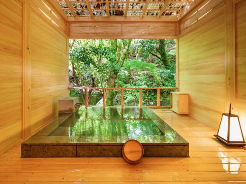 河津町Mizumari的一间位于带窗户的房间中间的带池塘的房间