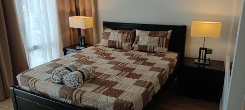 吉隆坡Anggun Residences 1500sqft 3BR KL TOWER KLCC的一间卧室配有一张带枕头的床和两盏灯。