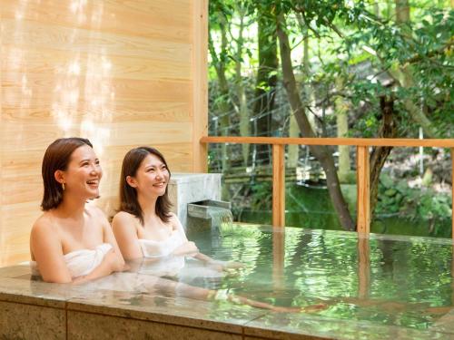河津町Mizumari的两名妇女坐在热水浴缸中