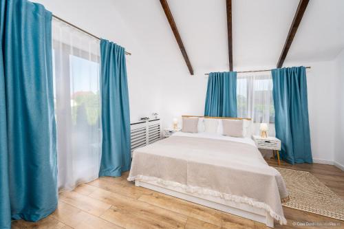 苏恰瓦Casa Dora的一间卧室配有一张带蓝色窗帘的大床