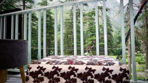 卡索尔Odin Hostel Kasol的树景门廊上的一张床