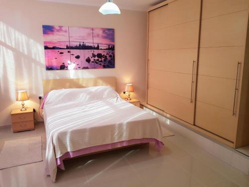 马尔萨斯卡拉Charming apartment-wifi-sleeps 5的卧室配有一张床,墙上挂有绘画作品