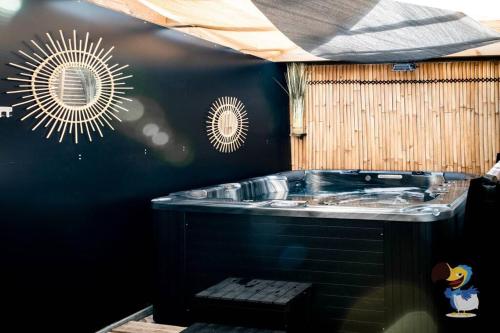 勒唐蓬L'intemporelle - Piscine et Spa的一间带黑色墙壁的热水浴缸的浴室