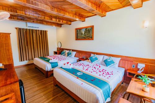 富国Palm Bay Resort Phu Quoc的酒店客房设有两张床和一张桌子。
