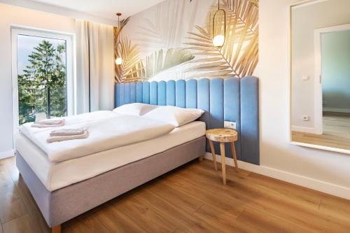 梅尔诺VacationClub – Sosnowa 4 Apartament 40的一间卧室配有一张蓝色床头板的床