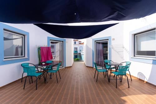 米尔芳提斯城Mar- Milfontes Rentals的一间带桌椅的用餐室和蓝色帐篷