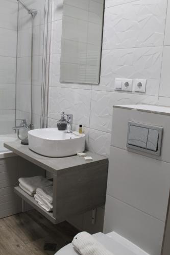 锡比乌Green Apartment的白色的浴室设有水槽和镜子