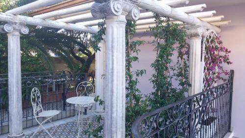 圣焦万尼泰亚蒂诺B&B Domus Aurea 20的阳台凉亭,配有桌椅