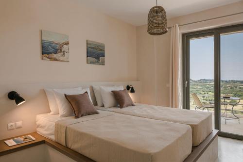 LépedhaVilla Lavanta - Iris sunset villas的一间卧室设有一张大床和一个大窗户