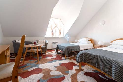 哈普萨卢海尔玛努斯玛雅酒店的一间卧室配有两张床、一张桌子和一把椅子