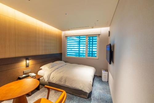 仁川市仁川机场1号航站楼过境酒店的一间卧室配有一张床、一张桌子和一个窗户。