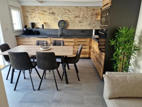 莱萨布勒-多洛讷la maison de léo的一间带木桌和椅子的用餐室
