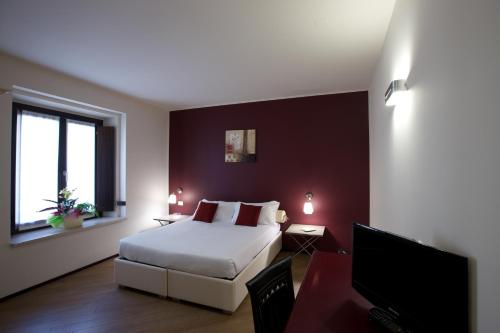 曼托瓦Hotel Leon D'Oro的一间卧室配有一张床和一台平面电视
