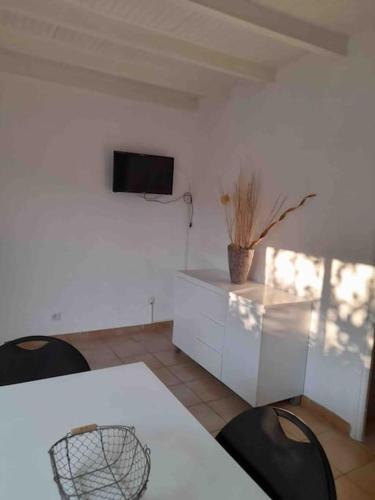 滨海阿热莱斯Charmant appartement de vacances的客厅配有桌椅和电视。