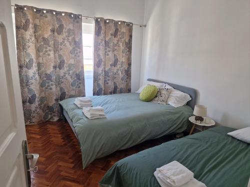 里斯本Alojamento Mercado Norte的一间卧室设有两张单人床和一个窗户。