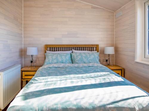 WillingtonAspen Lodge的一间卧室配有一张床、两个床头柜和两盏灯。