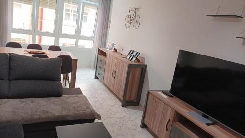 拉赫Apartamento A Atalaia的客厅配有电视和桌椅