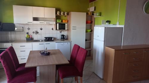 巴什卡沃达Apartmani Leko Mirjana的厨房配有桌椅和冰箱。