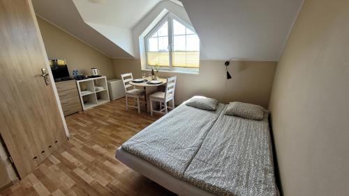 米耶伦科Kwatery Mielenko Patraj的一间卧室配有一张床、一张桌子和一个窗户。