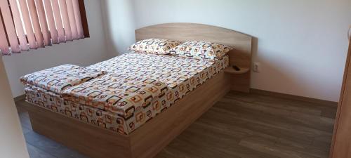 索瓦塔Betula Apartman的一间卧室配有一张带木制床头板和枕头的床。